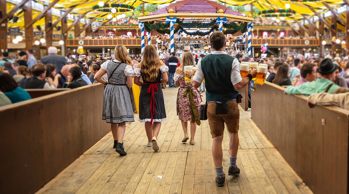 People walking through a decorated beer tent carrying beer